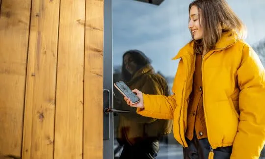woman opens exterior smart door lock