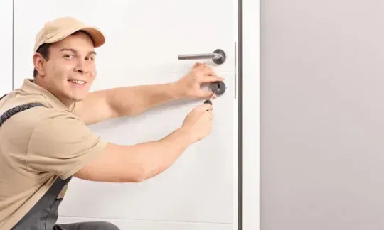 locksmith repairs a door lock