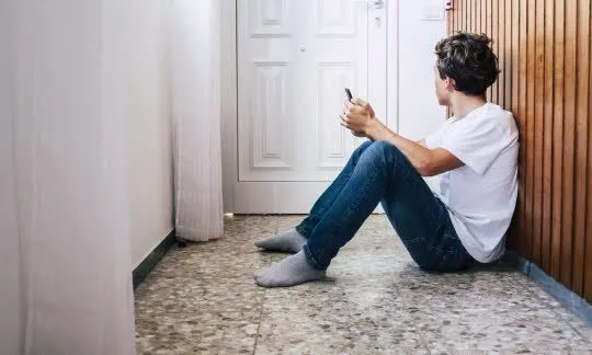 guy is sitting in front of closed door