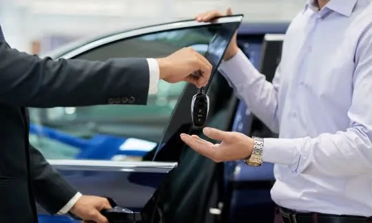 man gives a key fob to another man