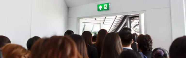 What kind of locks must emergency exit doors have