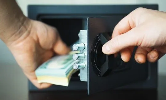 man put money in safe