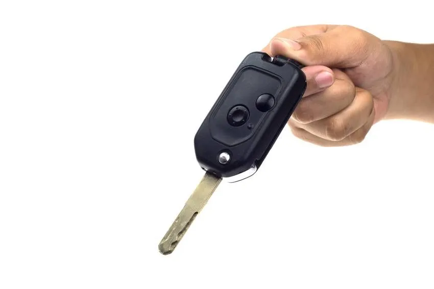 Driver hand with a car key isolated on white background